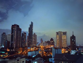 Illuminated buildings in city against sky at night