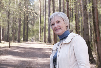 Portrait of smiling man standing in forest