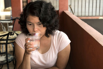 Portrait of young man drinking glass