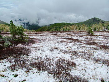 Scenic view of land and mountains against sky