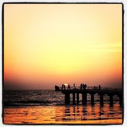 Pier on sea at sunset