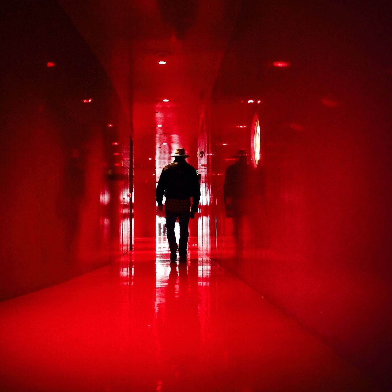 indoors, illuminated, rear view, lifestyles, walking, full length, men, tunnel, standing, corridor, silhouette, night, the way forward, architecture, person, built structure, leisure activity, red