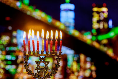 Close-up of illuminated candles against building