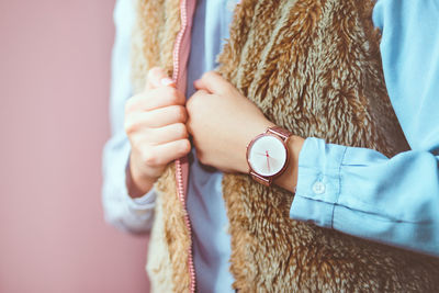 Midsection of woman wearing fur coat and wristwatch