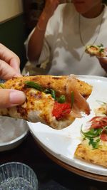 Delicious italian handmade pizza, prosciutto and arugula leaves, eating,closeup,hand holding food