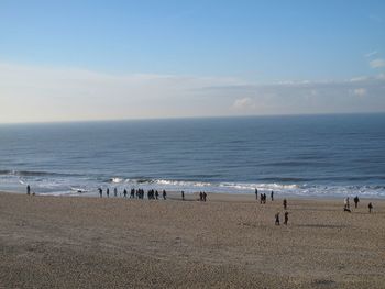 Group of people on beach against sky