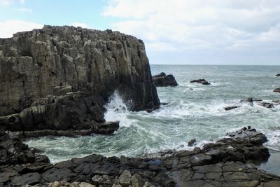 Scenic view of rocks in sea against sky