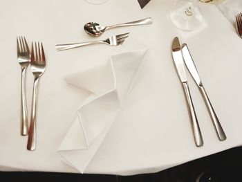 High angle view of cutlery and napkin on white table