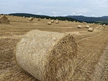 Hay bales on field against sky