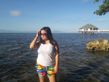 Portrait of beautiful young woman standing at beach