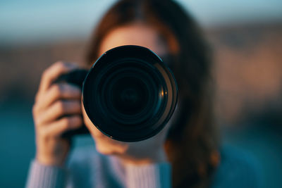 Close-up of woman photographing trough camera