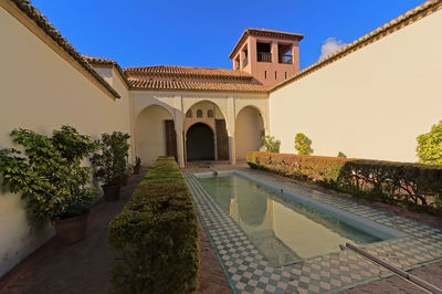 View of swimming pool by building against clear sky