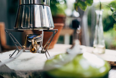 Close-up of espresso maker on camping stove on table