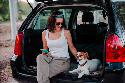 People with dog sitting in car