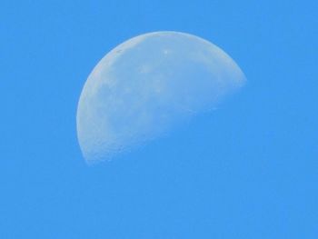 Low angle view of moon against blue sky