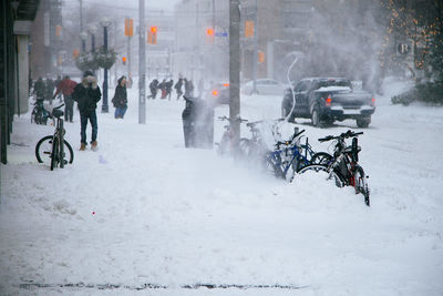 People walking in snow covered city