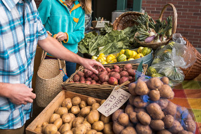 Man and woman gather potatoes at farmers market