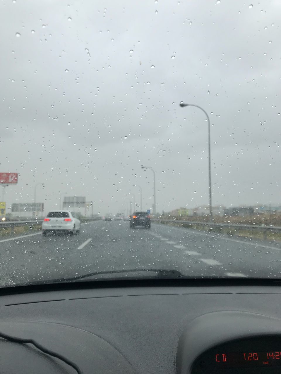 ROAD SEEN THROUGH WET CAR WINDOW