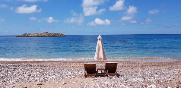 Lifeguard chair on beach against sky