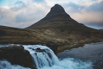 Scenic view of waterfall against sky