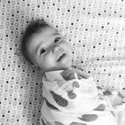 Portrait of baby lying on bed