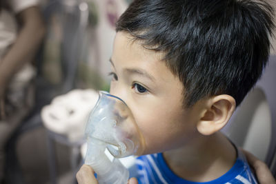 Close-up of boy wearing asthma inhaler