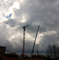 Low angle view of electricity pylon against dramatic sky