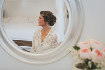 Reflection of mature woman on mirror in bedroom