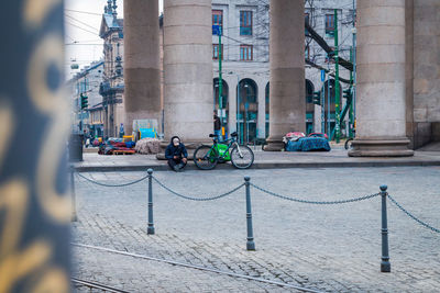 People on street against buildings in city