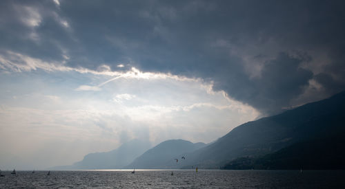 Scenic view of sea and mountains against sky