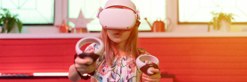 Vr game virtual reality. kid girl gamer playing on futuristic simulation video game in 3d glasses