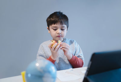 Boy looking at camera on table