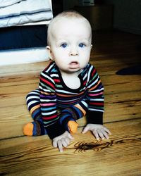 High angle portrait of baby sitting on floor at home