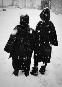 Rear view of boys standing on snow