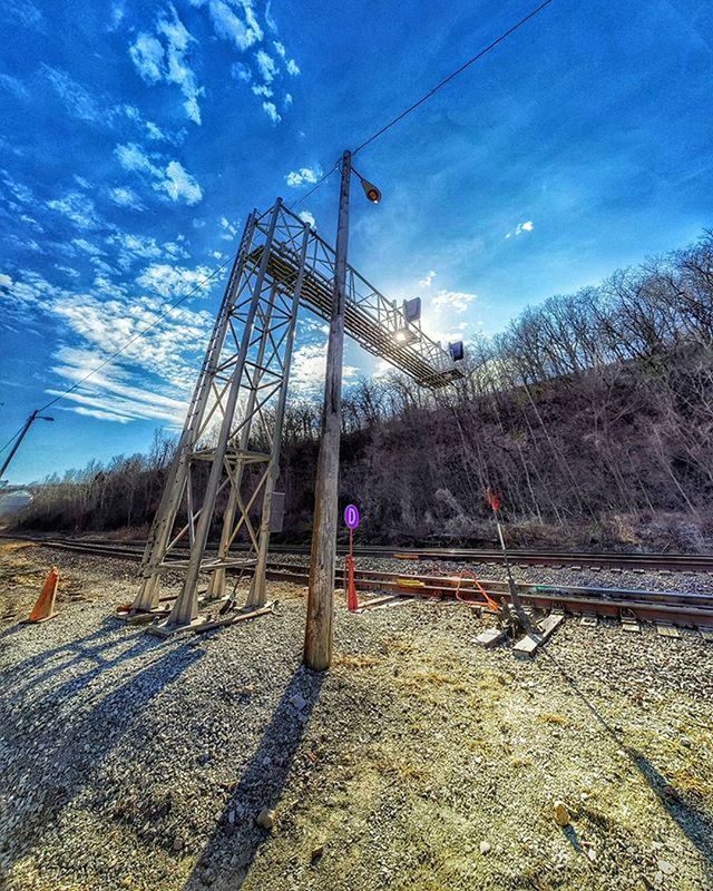 sky, built structure, architecture, cloud - sky, blue, connection, cloud, electricity pylon, low angle view, fuel and power generation, power line, day, sunlight, outdoors, building exterior, construction site, no people, industry, field, landscape