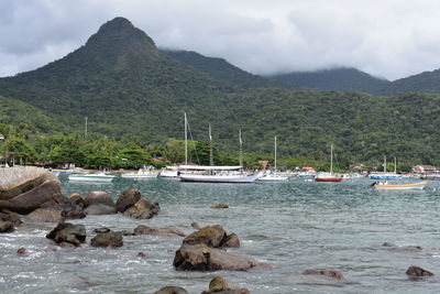 Scenic view of sea and mountains against sky