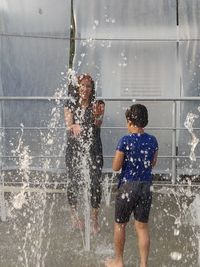 Rear view of people enjoying at water