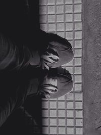 Low section of man standing on tiled floor