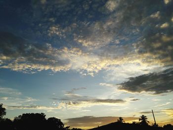 Silhouette of trees against cloudy sky