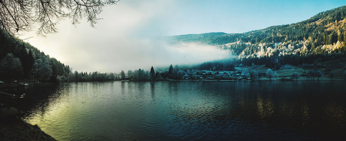 Scenic view of lake by trees against sky