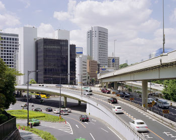 Traffic on highway in city against sky