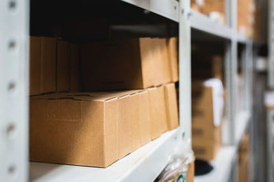 Rows of shelves with cardboard boxes in a modern warehouse, close-up. brown boxes on metal shelving