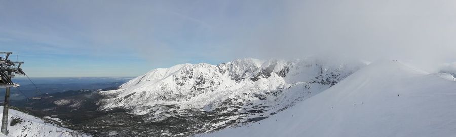 Scenic view of snow covered mountains against sky