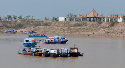 Boats moored on lake against clear sky