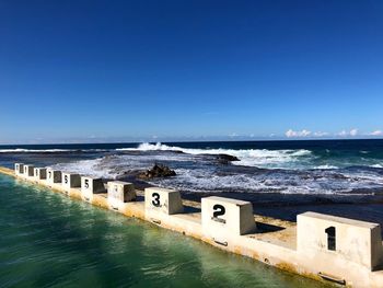 Starting blocks on ocean pool with waves and sea view against clear blue sky in newcastle, australia 