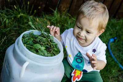 Full length of boy holding plants