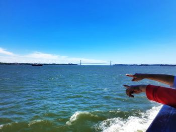 Man holding sea against blue sky