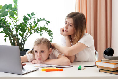 Mother helping daughter with homework