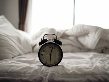 Close-up of clock on the bed