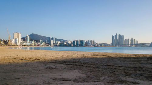 Sea and buildings against clear sky